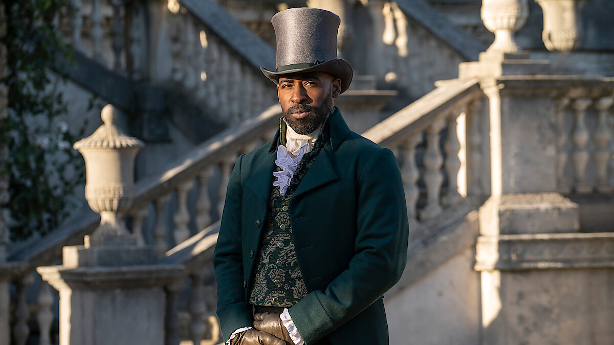 A man in Victorian-era formal attire and top hat stands outside in front of elegant stone steps and balustrades, with classic architecture in the background.