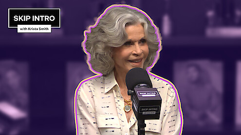 Jane Fonda sitting in front of a microphone, with the 'Skip Intro' logo positioned in the upper left corner.