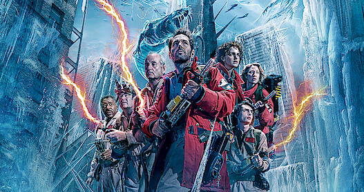 The cast of 'Ghostbusters: Frozen Empire' stand wearing their gear in a frozen city 