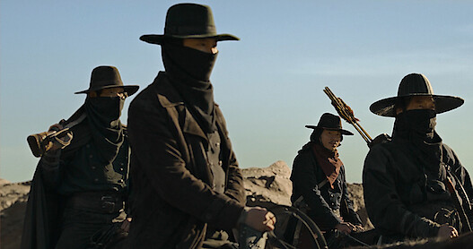A group of people ride horses wearing all black in Season 1 of 'Song of the Bandits.'