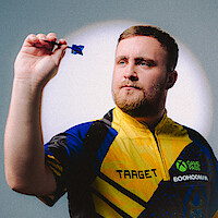 A focused man in a yellow and blue sports shirt holding a dart, preparing to throw, with a neutral indoor background and spotlight effect.