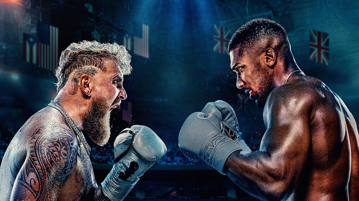 Jake Paul and Anthony Joshua face off shirtless in a dramatic, intense promotional poster with their country flags in the background