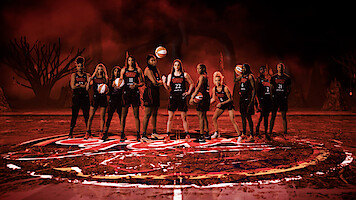 The Indiana Fever basketball team poses on a Stranger Things themed court.