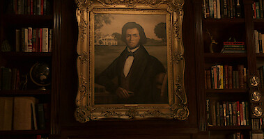 Um retrato emoldurado de Denmark Tanny na parede do escritório de Ward.