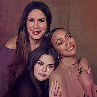 Selena Gomez, Karla Sofía Gascón, and Zoe Saldaña pose against a gray background. All three women wear black.