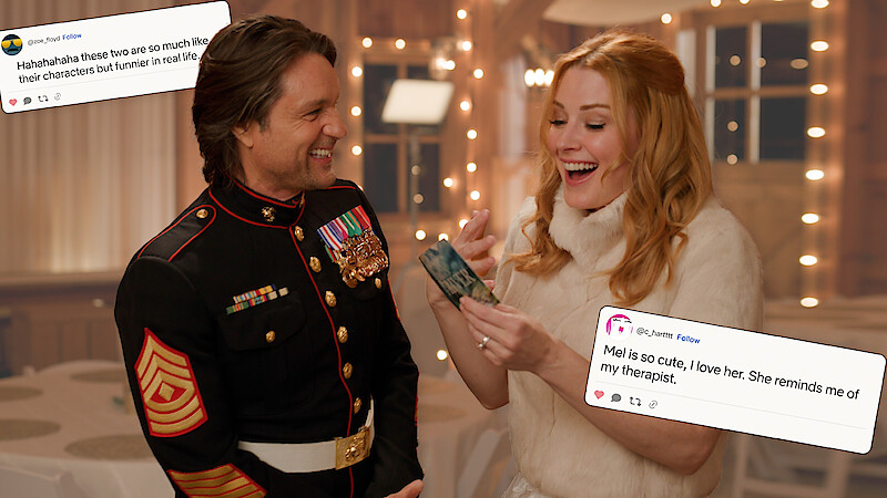 Martin Henderson and Alexandra Breckenridge smiling as they react to a comment from a fan written on a card.