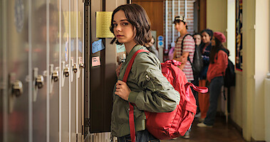 Emma Myers as Pip Fitz-Amobi stands in a high school hallway in front of a wall of lockers in 'A Good Girl's Guide to Murder'