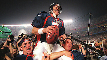 John Elway being carried by his teammates.