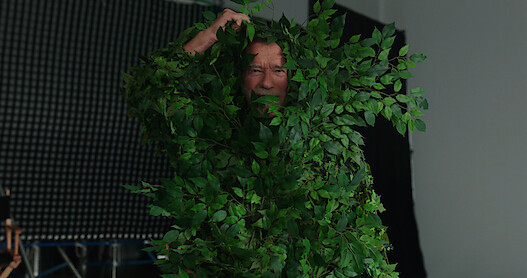Arnold Schwarzenegger in a fake plant on the set of 'FUBAR'