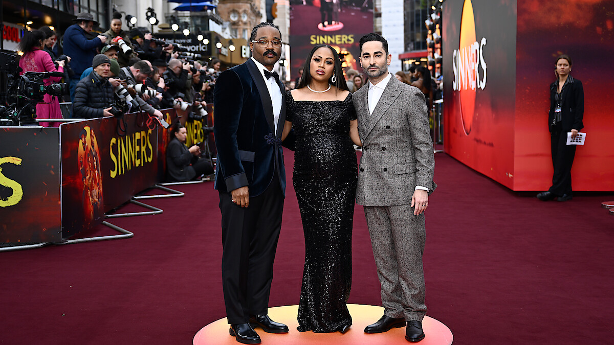 A trio stands on the red carpet. 
