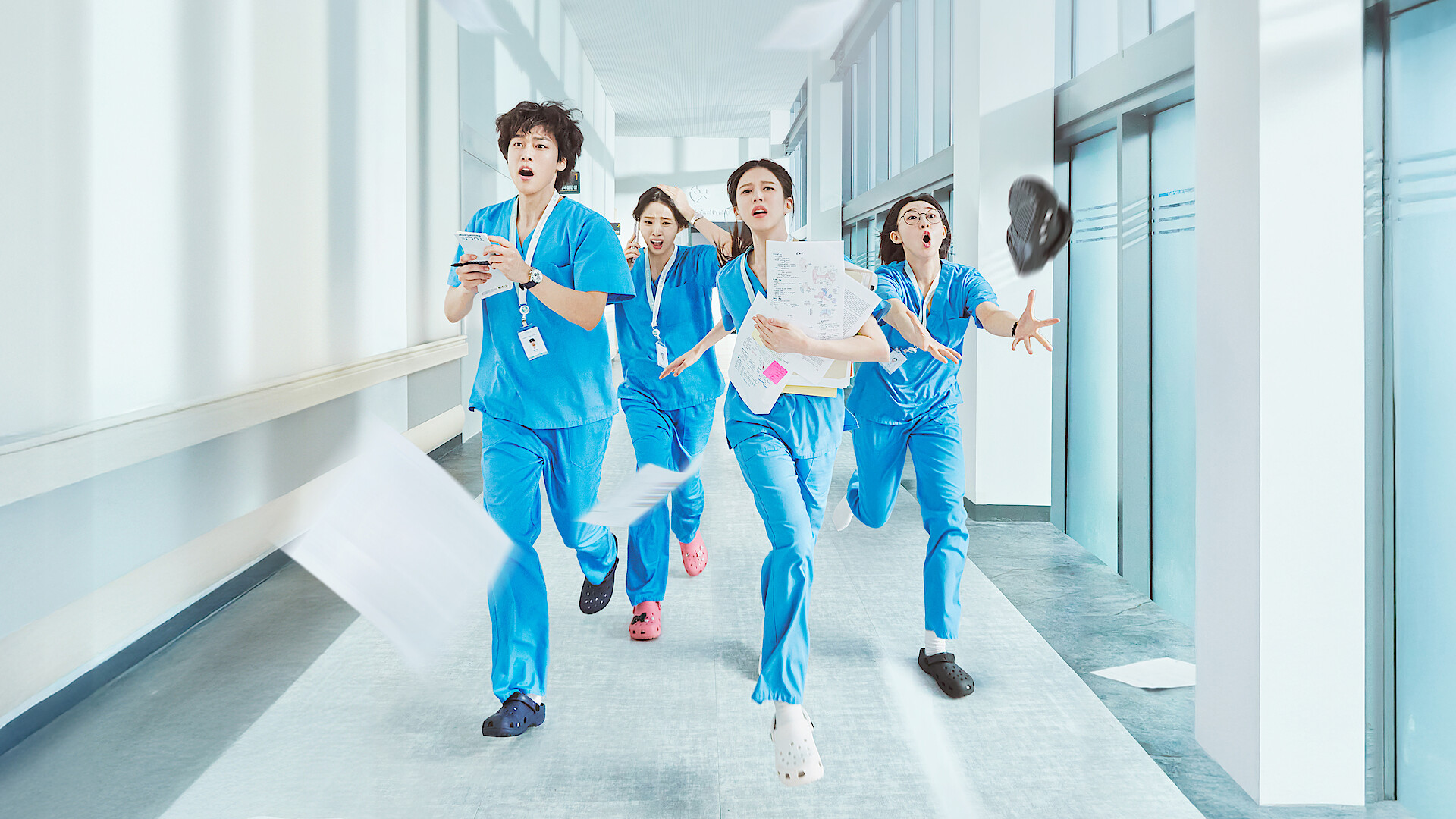 Resident Playbook - The Resident Cast dressed in scrubs running down a hallway. 