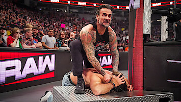 CM Punk attacks Seth Rollins outside of the ring during WWE RAW