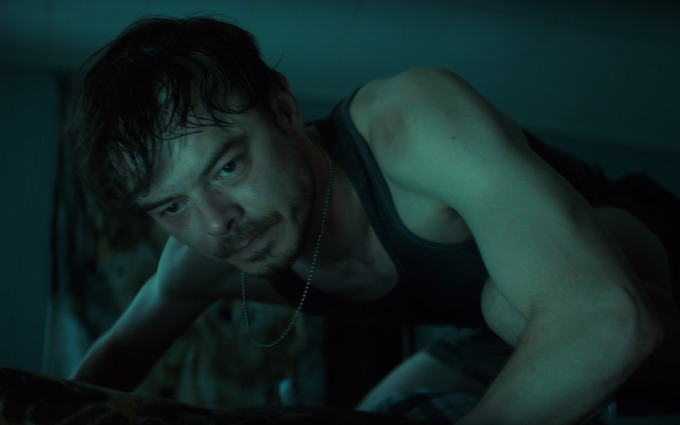 Charlie Heaton as Wade Penney in Below Charlie Heaton as Wade Penney in a tense dimly lit scene from Netflix Below