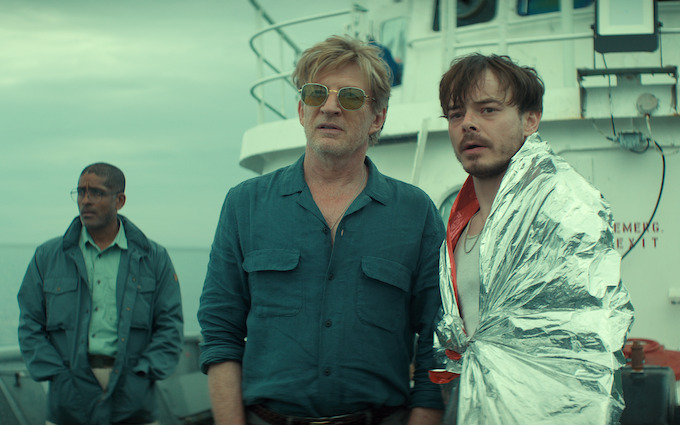 Wade Penney and other characters aboard a boat in Below Three characters including Wade Penney stand aboard a boat in Netflix Below