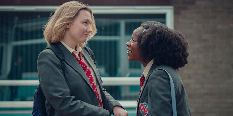 Two girls looking at each other holding hands