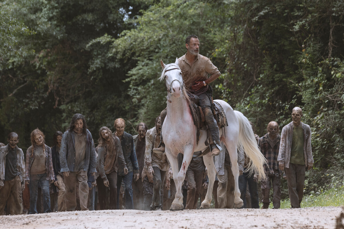 Rick on a horse leading a group of zombies