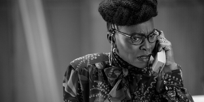 Black and white image of Rakie Ayola as Persephone taking a phone call in Season 1 of ‘Kaos’