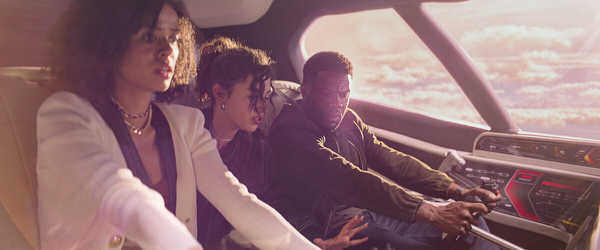 Gugu Mbatha-Raw as Abby, Úrsula Corberó as Camila, and Kevin Hart as Cyrus flying a plane in ‘Lift’