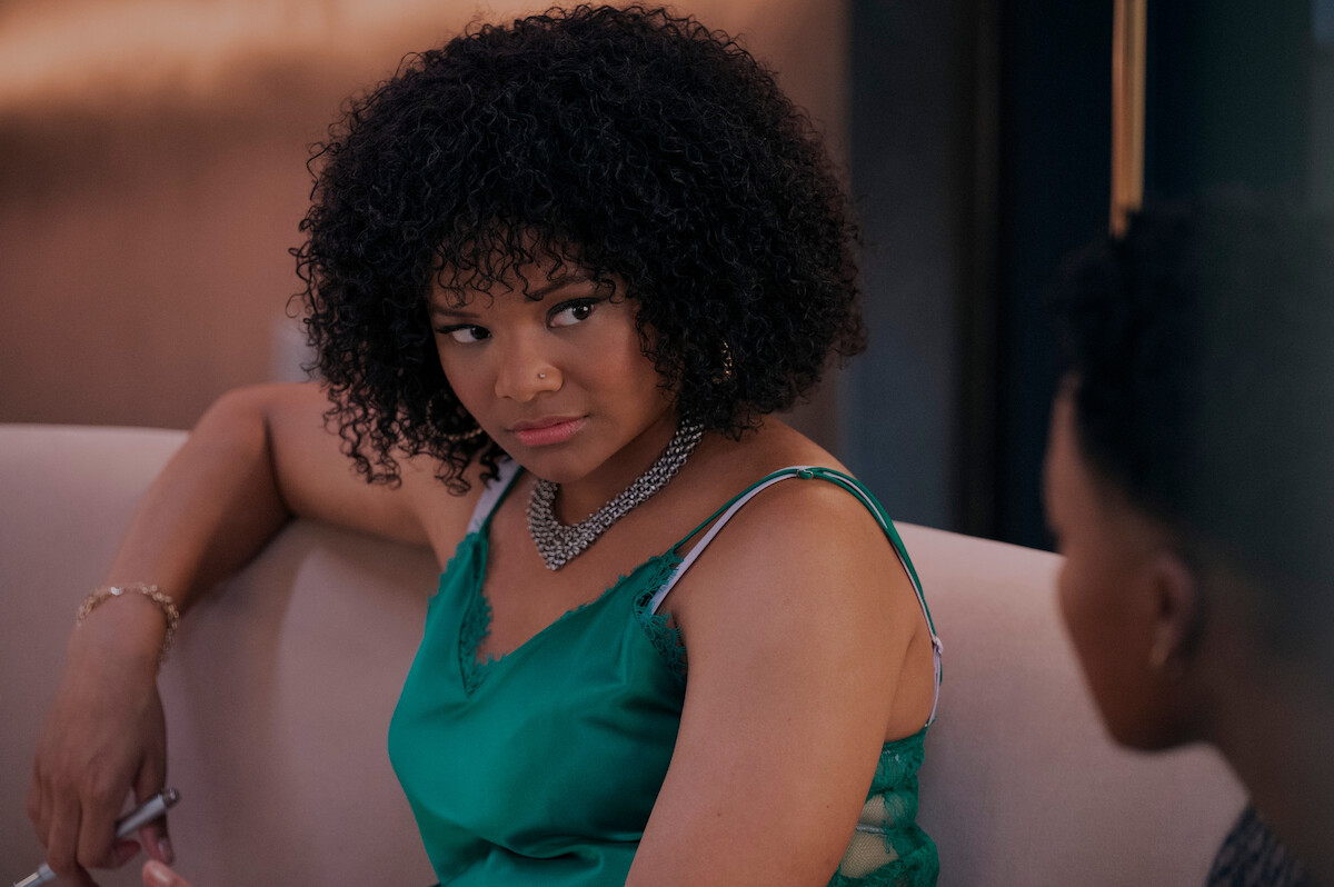 Jade Payton as Venetia in ‘Glamorous’ Season 1 sitting on a couch.