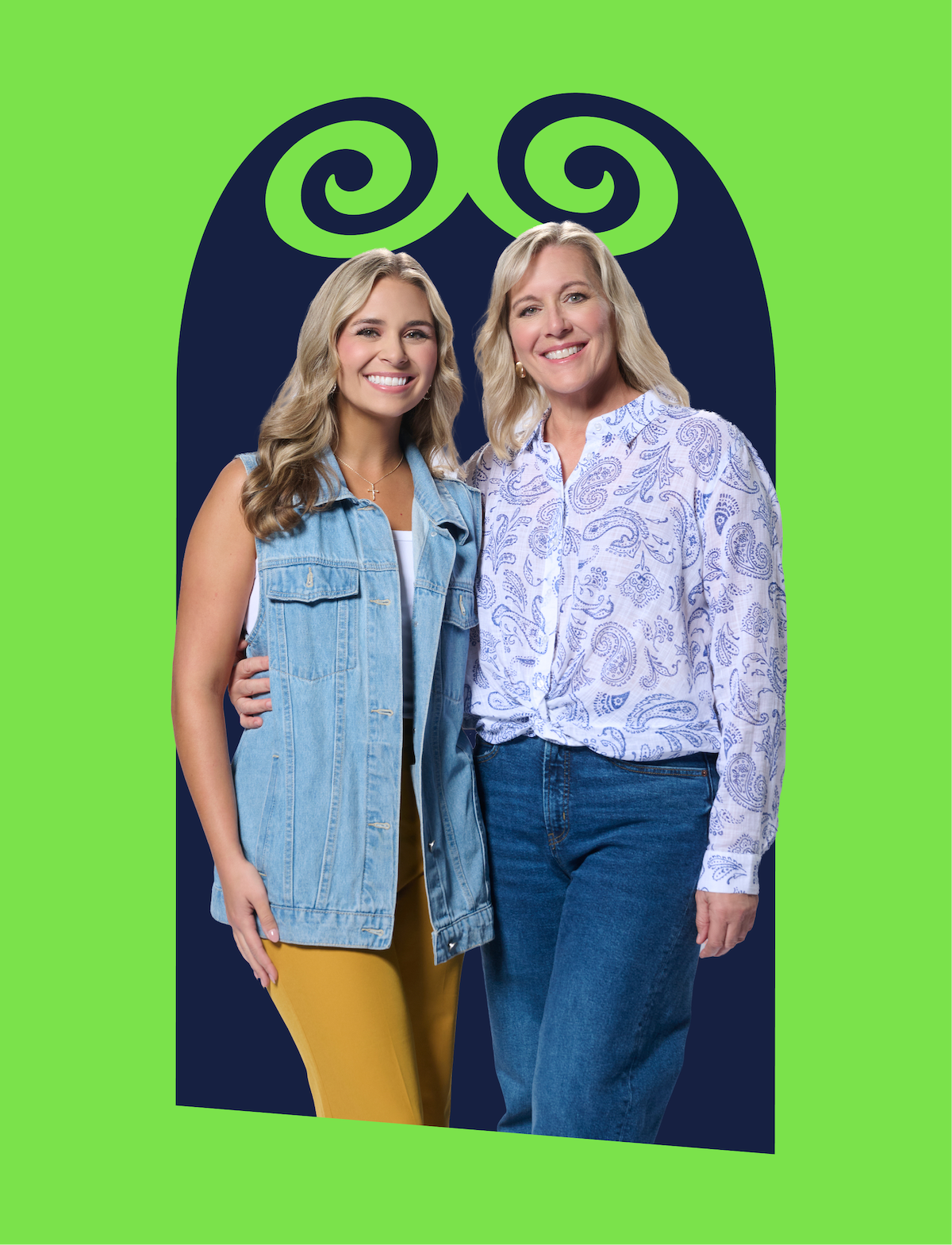 Duas mulheres sorridentes estão juntas de pé; uma veste um colete jeans e calça amarela, a outra, uma camisa branca com estampa paisley e calça jeans. Elas estão em frente a um arco azul‑marinho com espirais verdes, sobre um fundo verde brilhante.