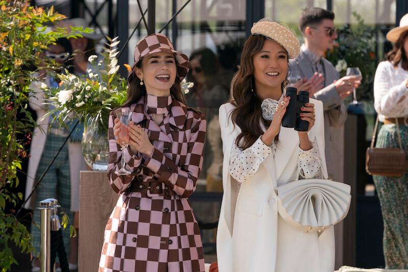 Lily Collins as Emily and Ashley Park as Mindy walk down the street together in Season 4 of 'Emily in Paris'