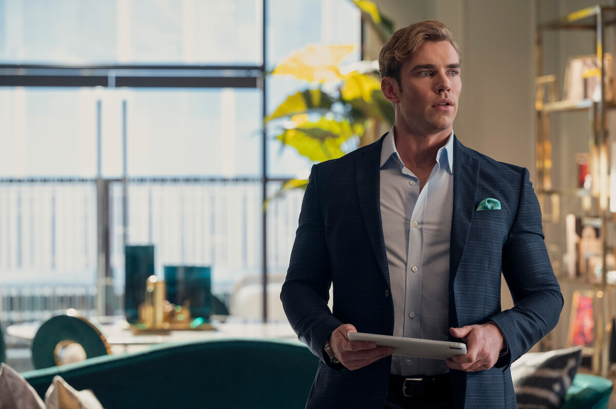 Zane Phillips as Chad in ‘Glamorous’ Season 1 standing in an office.
