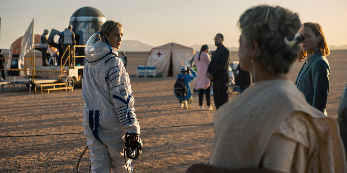 Peri Baumeister as Paula, wearing a space suit, looks over her shoulder in a still image from the German series ‘The Signal.’