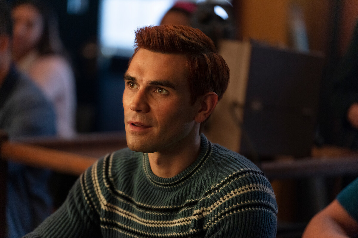 K.J. Apa as Archie Andrews sits with a serious expression in Season 7 of ‘Riverdale.’