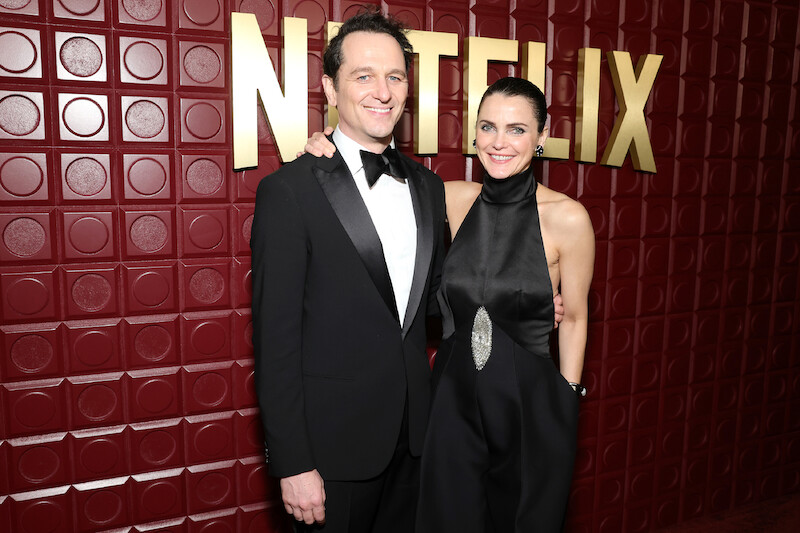 Matthew Rhys and Keri Russell stand in front of a red backdrop