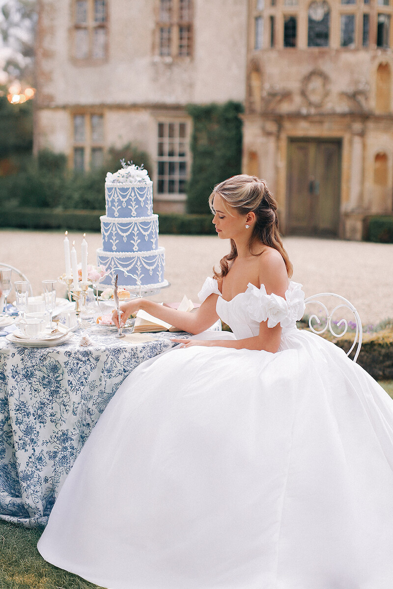 Woman in bridal dresses poses and looks off into the distance.