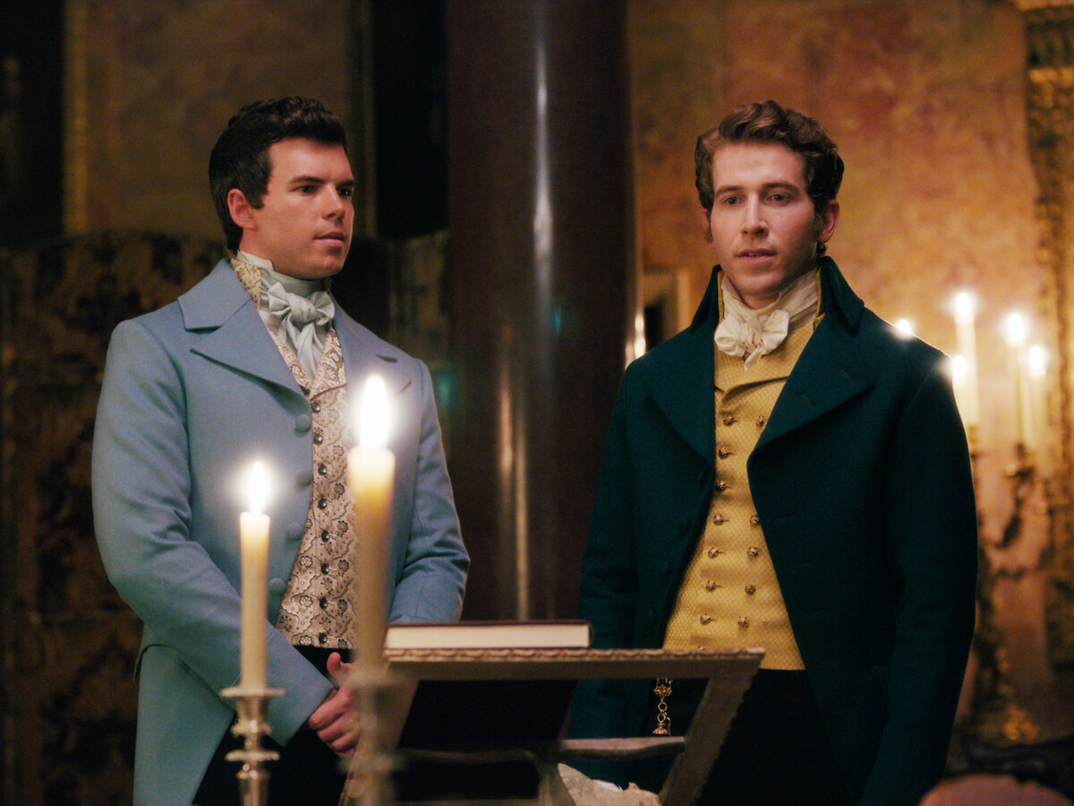 Colin Bridgerton and Phillip Crane stand in a room surrounded by candles.