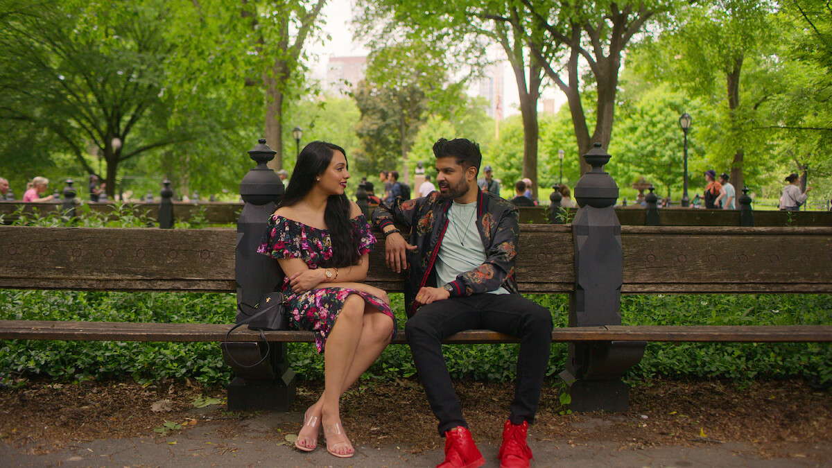 A couple sits on a bench during a date.