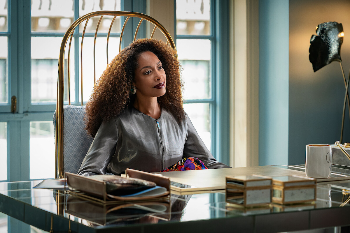 Gina Torres sits at a desk as Darcy Hill in a still from ‘The Perfect Find.’