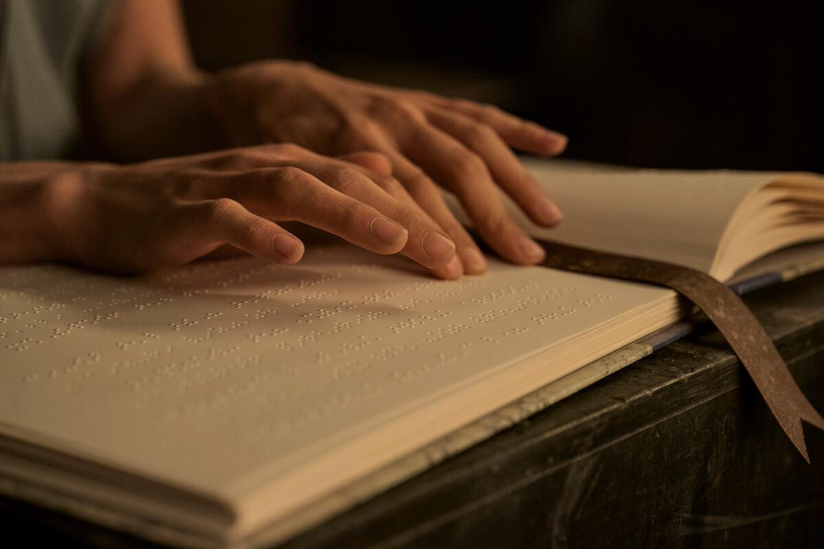 Hands reading brail.