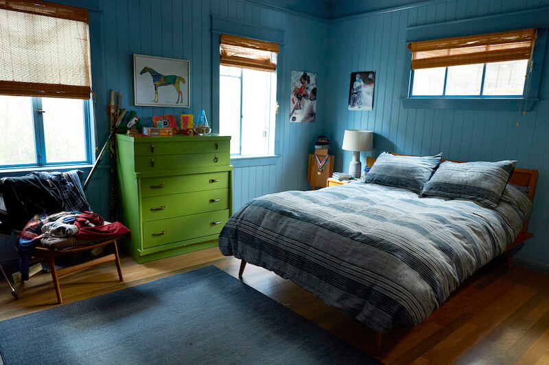 Bedroom with green dresser and blue walls.