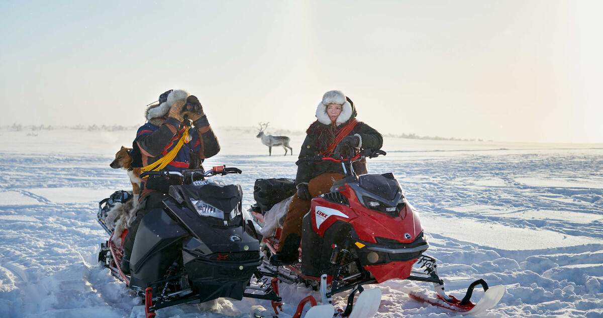 Lars-Ante Wasara as Mattias and Elin Oskal as Elsa sit on snowmobiles in 'Stolen.'