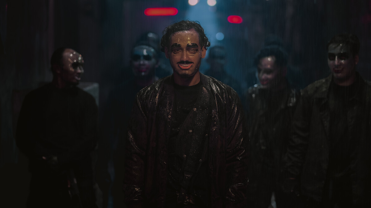 Masked people stand in a group on a darkened street in an image from ‘The Shadow Strays.’