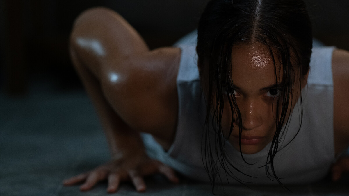 Aurora Ribero as 13 pushes against the floor with her hands as she lies on the floor in an image from the film ‘The Shadow Strays.’