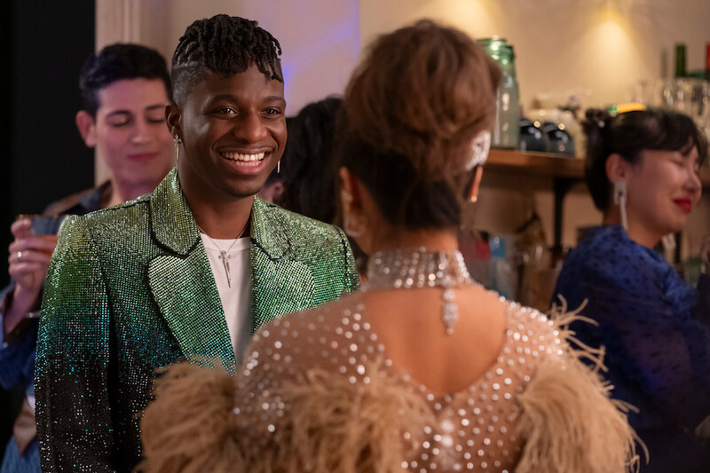 Samuel Arnold as Julien smiles at a party in Season 4 of 'Emily in Paris'