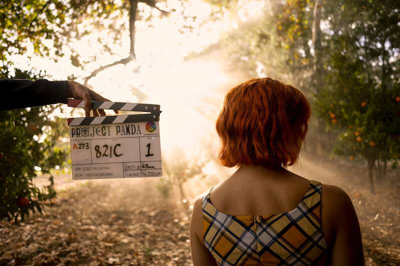 Emily Rudd as Nami stands with her back turned to the camera with a clapboard next to her in Season 1 of 'One Piece.'