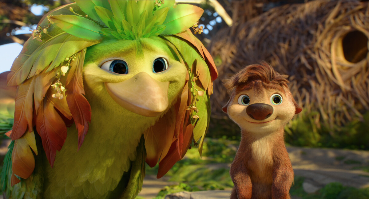 Colorful animated bird with leafy feathers and a smiling furry animal stand together outside in a bright, nature-filled environment with trees and a large round nest in the background.