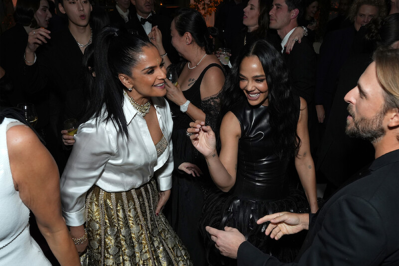 Bela Bajaria and Tessa Thompson dance in a crowd.