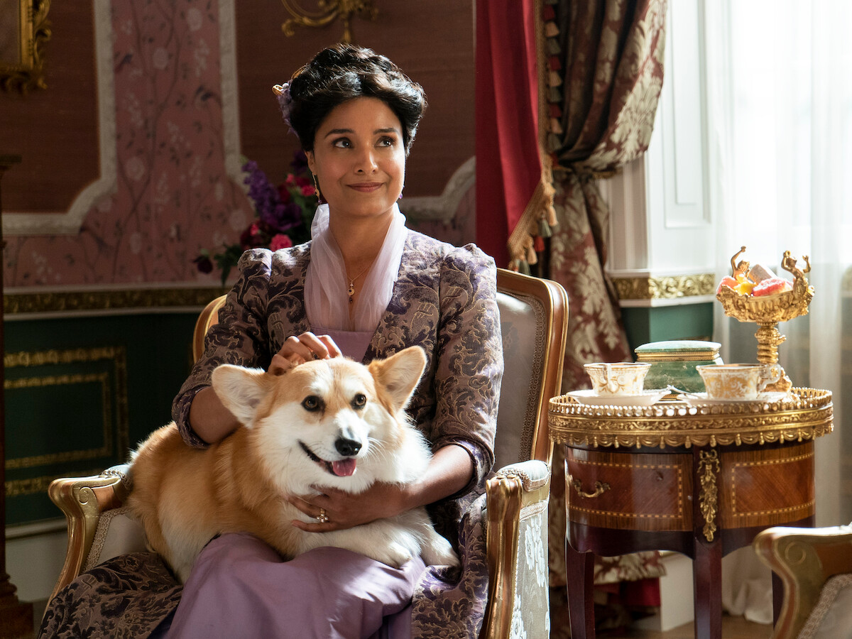 Lady Mary smiles with Newton the dog on her lap.