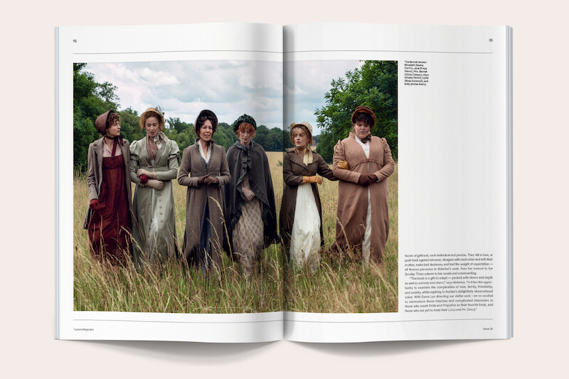 Six women in period costumes stand in a grassy field with trees and a cloudy sky in the background, featured in a magazine spread with text on the right page.