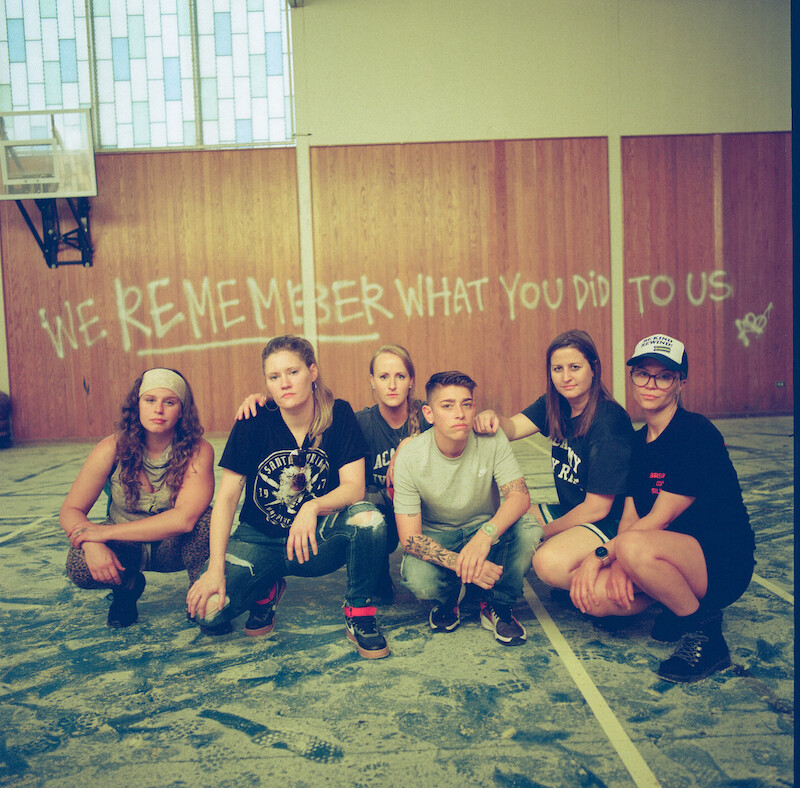 Katherine Kubler and team squatting in an empty room at The Academy at Ivy Ridge. 