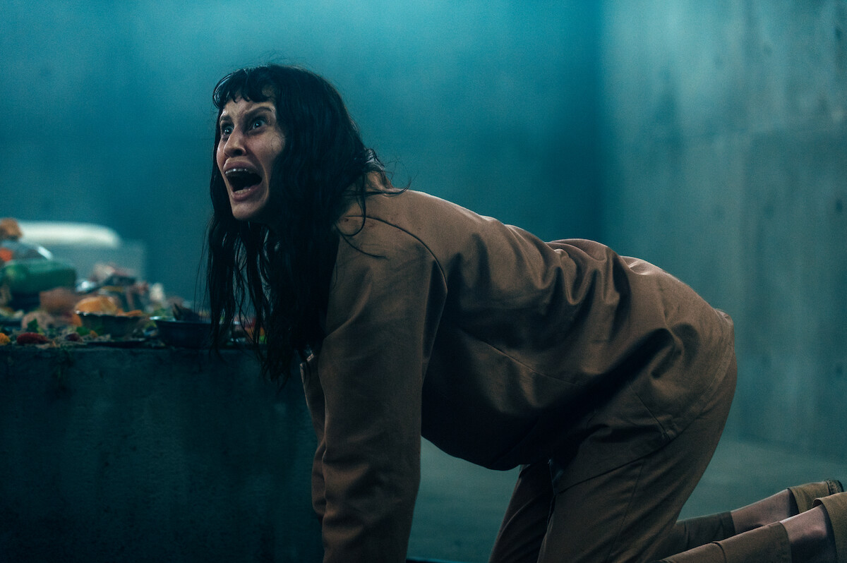 Milena Smit as Perempuán crawls on the ground on all fours while screaming in an image from the film ‘The Platform 2’