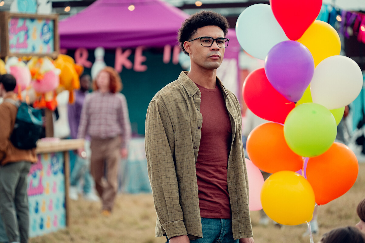 Darragh Hand as Michael stands alone at a carnival in Season 3 of ‘Heartstopper.’