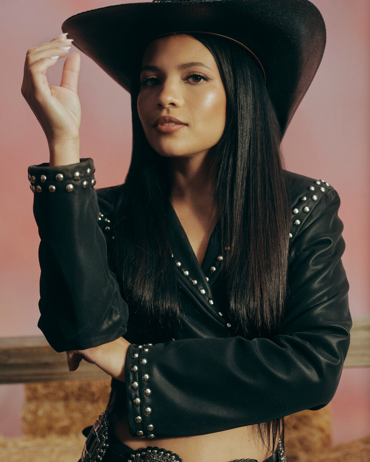Nikki Rodriguez usando chapéu de caubói e jaqueta de couro.