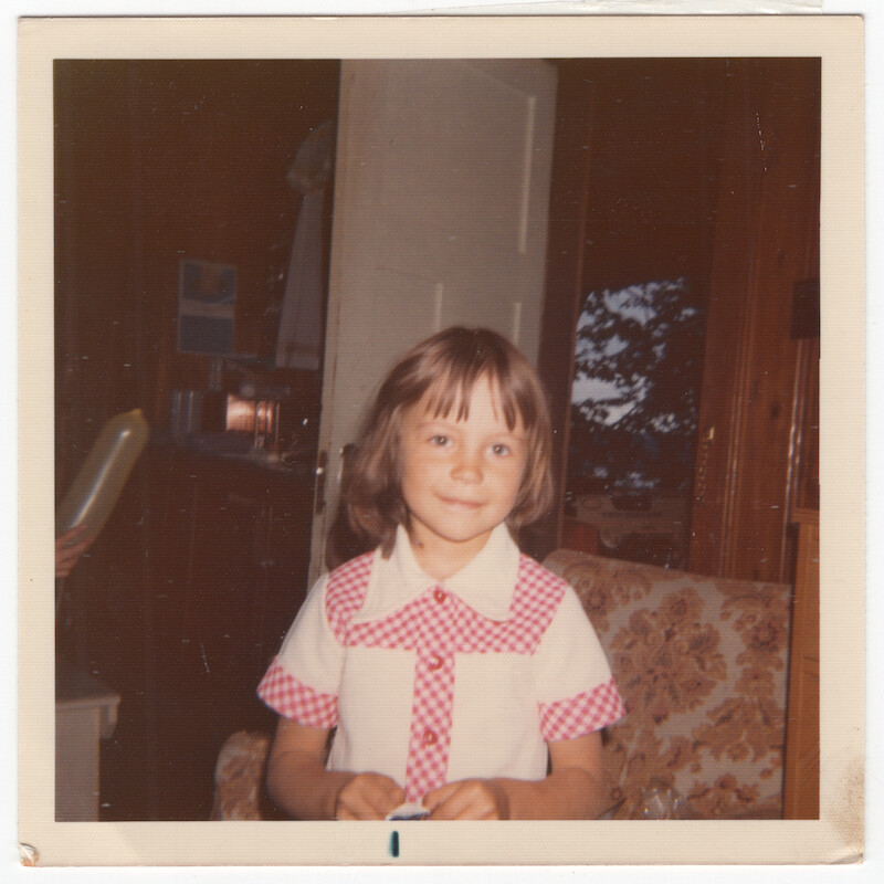 Pamela as a child in a checkered blouse.