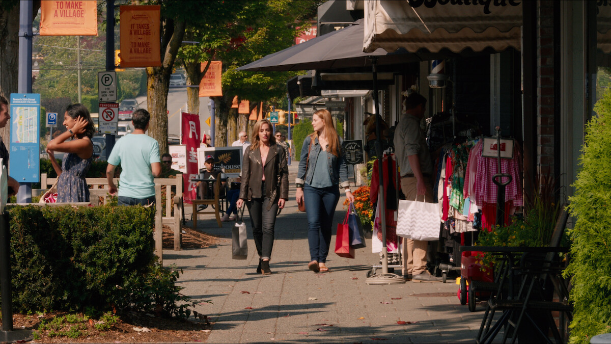 Zibby Allen as Brie Sheridan and Alexandra Breckenridge as Mel Monroe walk down a sidewalk carrying shopping bags in ‘Virgin River.’